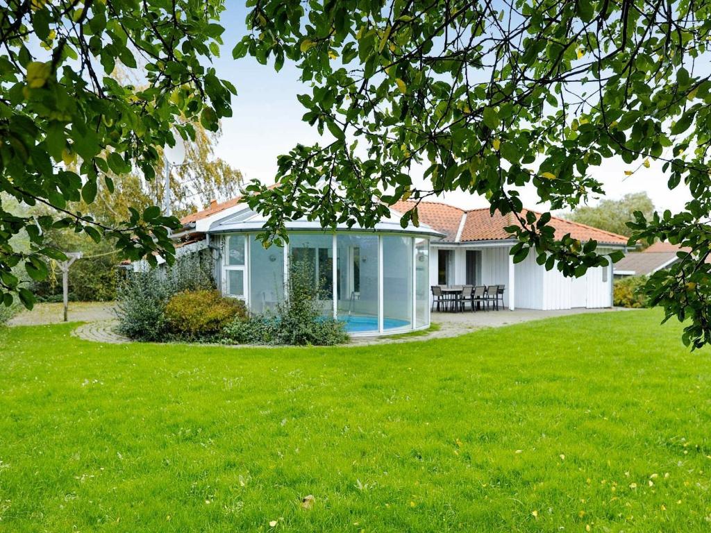 a house with a green lawn in front of it at 8 person holiday home in Juelsminde in Sønderby