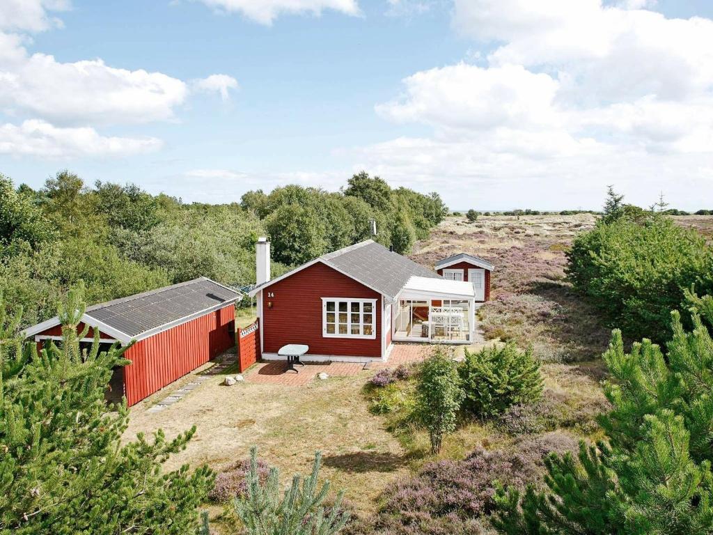 een rood huis in het midden van een veld bij 6 person holiday home in lb k in Ålbæk