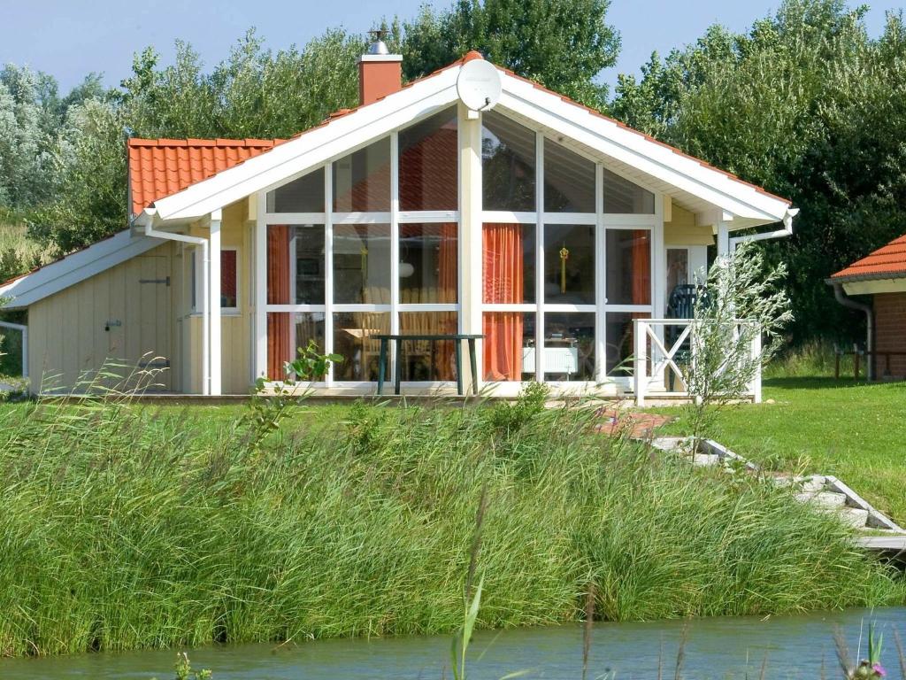 オッテルンドルフにある6 person holiday home in Otterndorfの川の景色を望むコテージ