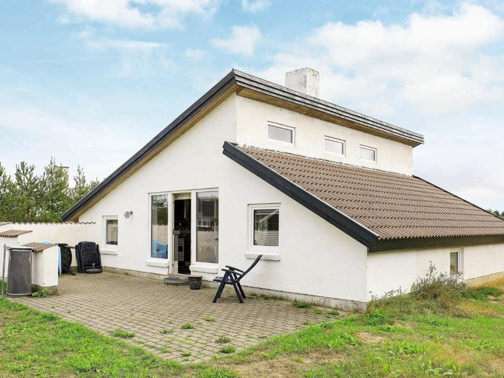 una casa blanca con un patio delante en Three-Bedroom Holiday home in Thisted 4, en Nørre Vorupør
