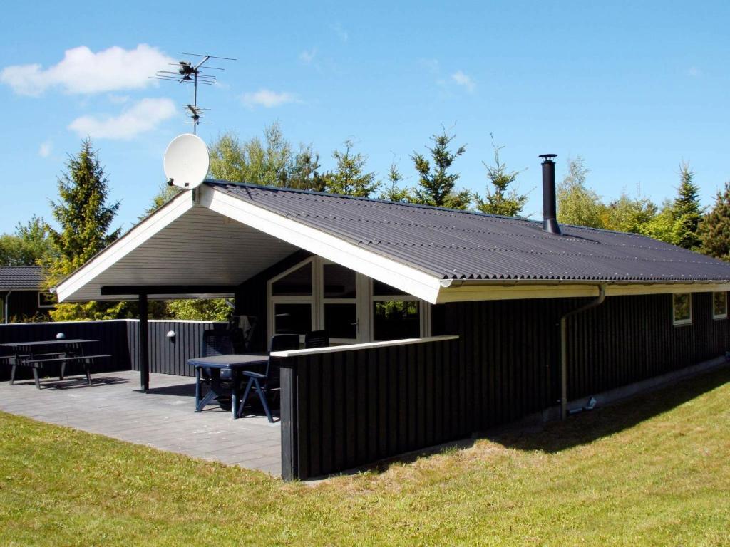 a building with a roof with a picnic table on it at 6 person holiday home in Fjerritslev in Fjerritslev