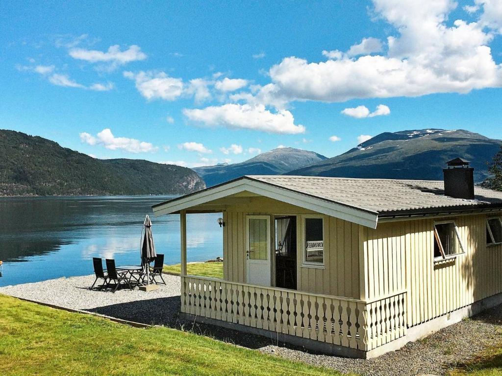 a small house next to a body of water at Two-Bedroom Holiday home in Utvik 3 in Reed