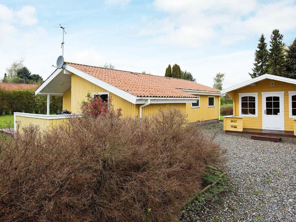 uma casa amarela com um telhado vermelho em 8 person holiday home in Stege em Stege