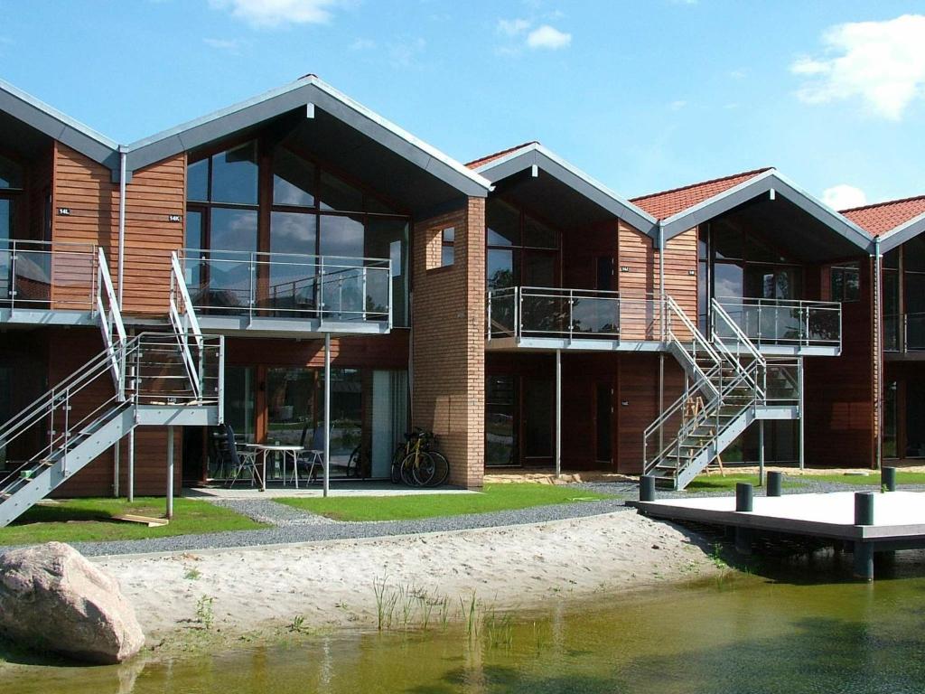 un edificio con escaleras junto a una masa de agua en Two-Bedroom Holiday home in Bogense 7, en Bogense