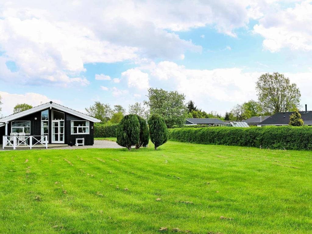 Øster Hurupにある6 person holiday home in Hadsundの前方に広い緑地がある家