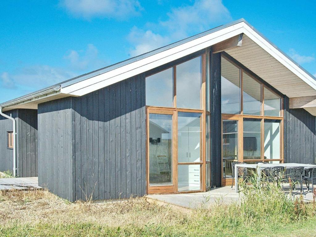 ein Haus mit großen Glasfenstern an der Seite in der Unterkunft 8 person holiday home in Ulfborg in Thorsminde