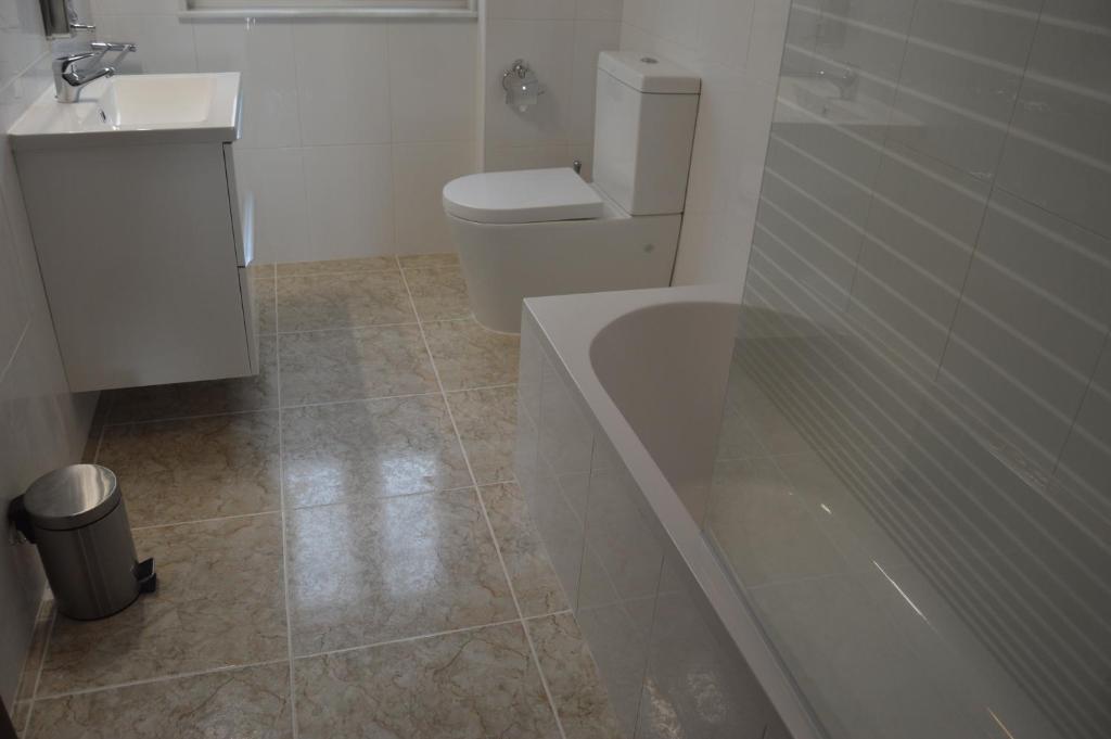 łazienka z toaletą, umywalką i wanną w obiekcie Casa Playa de Rostro w mieście Fisterra