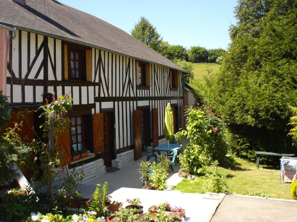 an old black and white house with a garden at Le Val Godard in Fresnay-le-Samson