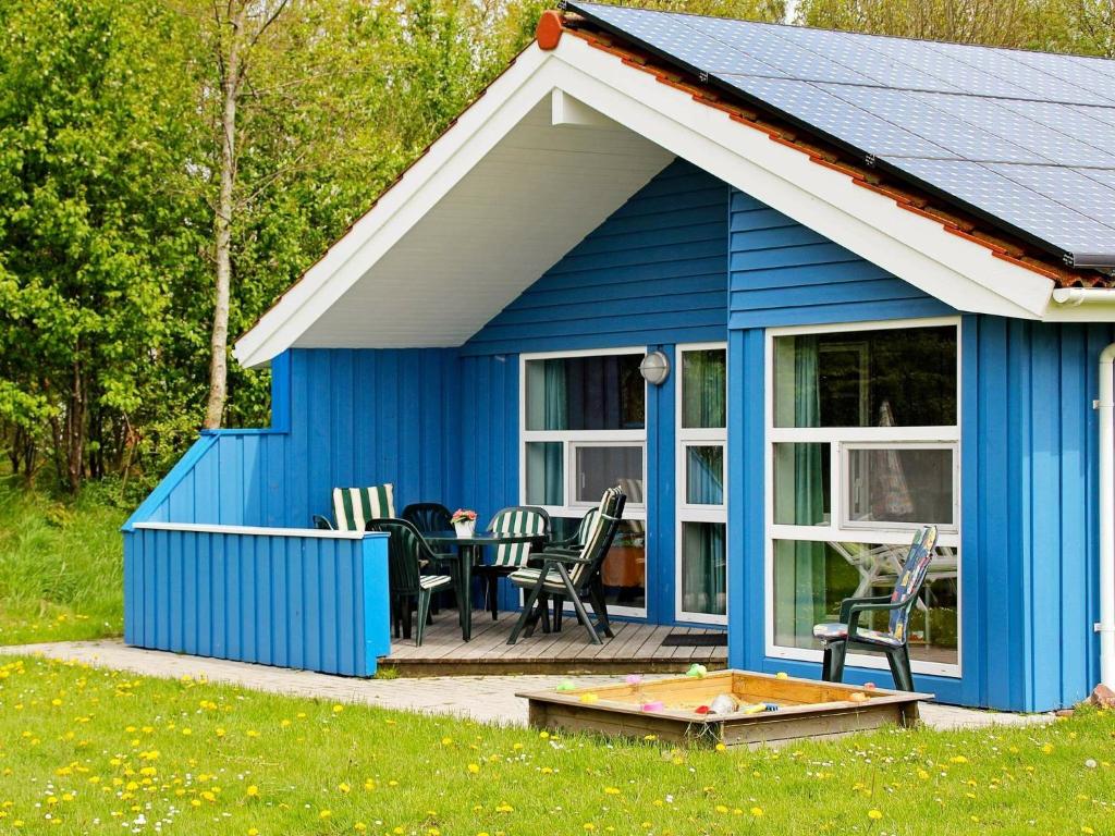 オッテルンドルフにある6 person holiday home in Otterndorfの青い小屋(テーブル、椅子付)
