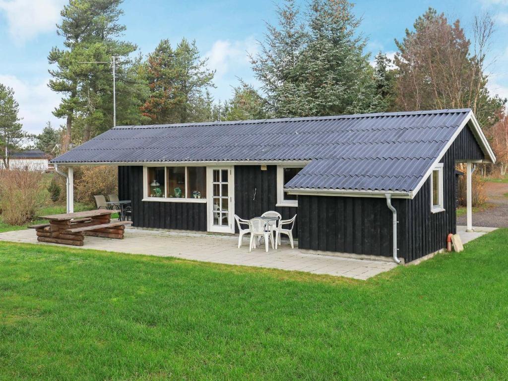 cobertizo blanco y negro con patio y mesa en 6 person holiday home in S by en Sæby