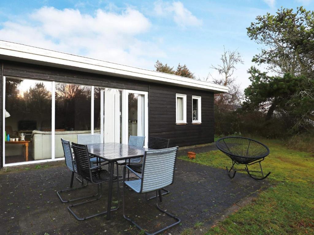 a patio with a table and chairs and a house at 6 person holiday home in Thisted in Klitmøller