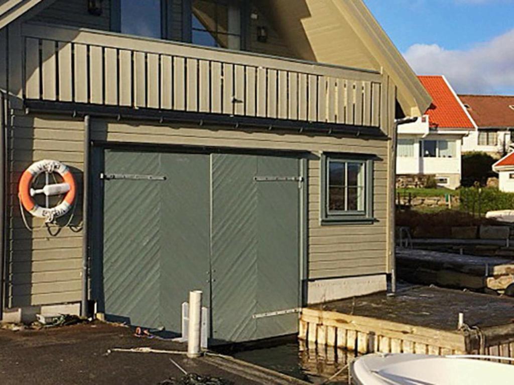 ein Gebäude mit einer grünen Garage mit einem orangefarbenen Rettungsring in der Unterkunft 7 person holiday home in bru in Bru