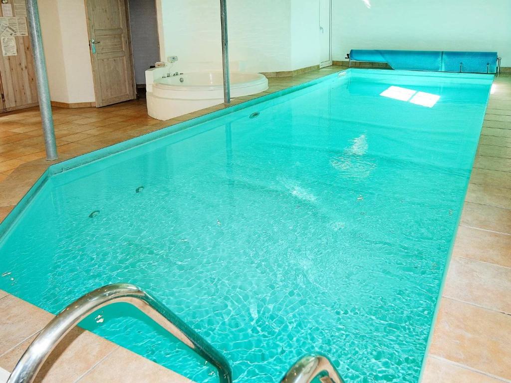 een zwembad met blauw water in een kamer bij Holiday Home Kongeørnen in Odde