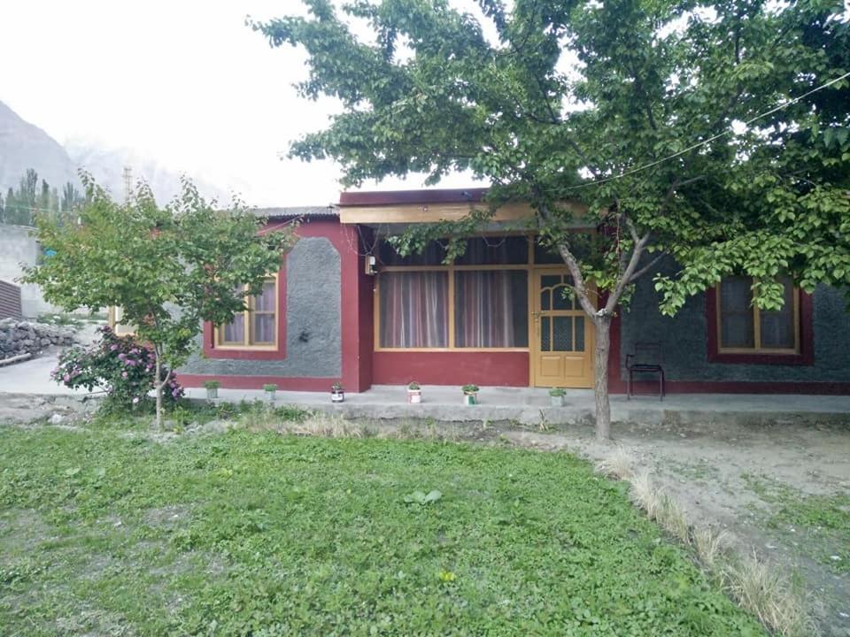 une maison avec un arbre en face dans l'établissement Guest House De Grand Imperial, à Hunza