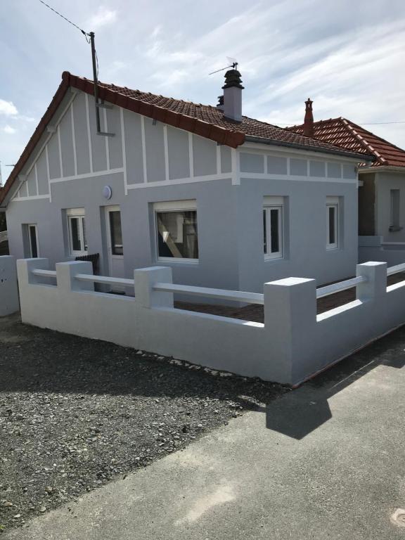 una casa blanca con una valla delante en Villa Proche Mer St Martin de BREHAL en Bréhal