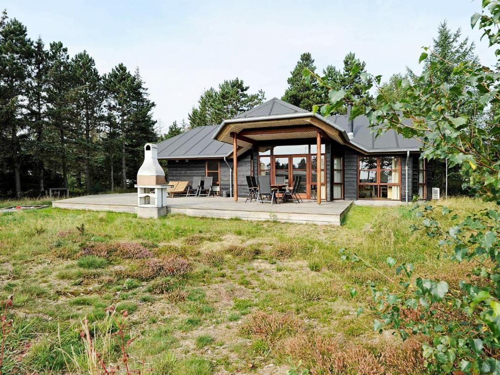 ein Haus auf einem Hügel mit einem Grasfeld in der Unterkunft 8 person holiday home in R m in Rømø Kirkeby