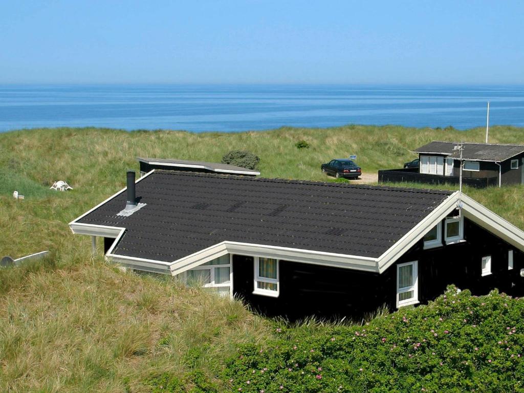 ロッケンにある6 person holiday home in L kkenの海を背景にした丘の上の家
