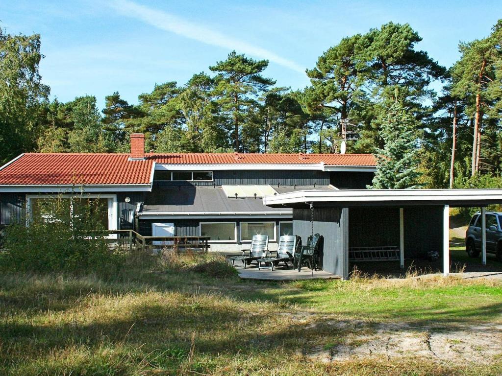 a house with a porch and chairs in the yard at 12 person holiday home in Nex in Snogebæk
