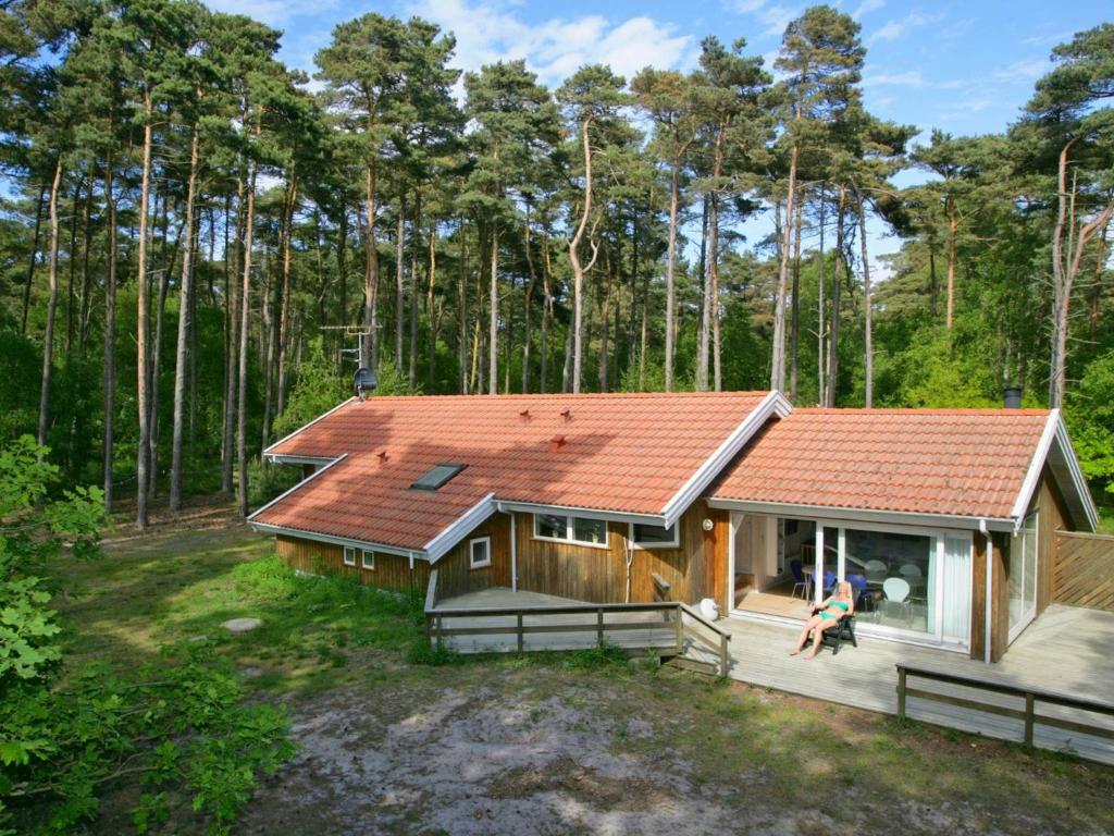 una casa con techo naranja en el bosque en Four-Bedroom Holiday home in Nexø 14, en Spidsegård