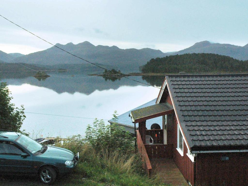 a car parked outside of a house with a view of a lake at Two-Bedroom Holiday home in Vågland 4 in Rabben