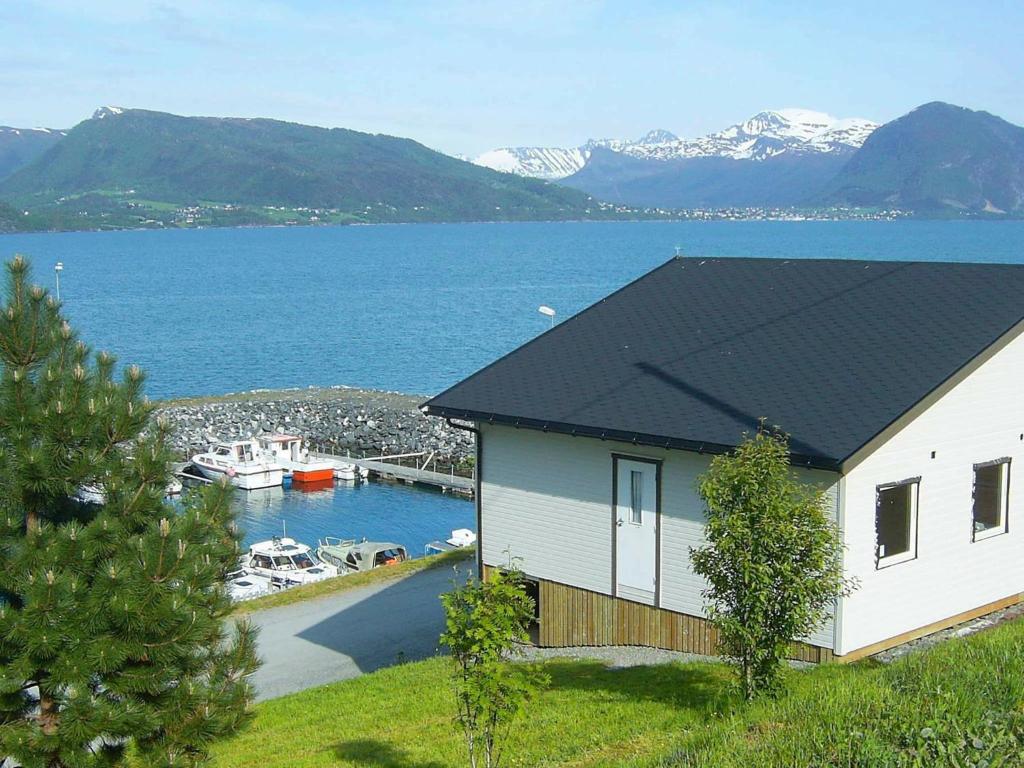 a house next to a marina with a boat in the water at 4 person holiday home in Lauvstad-By Traum in Lauvstad