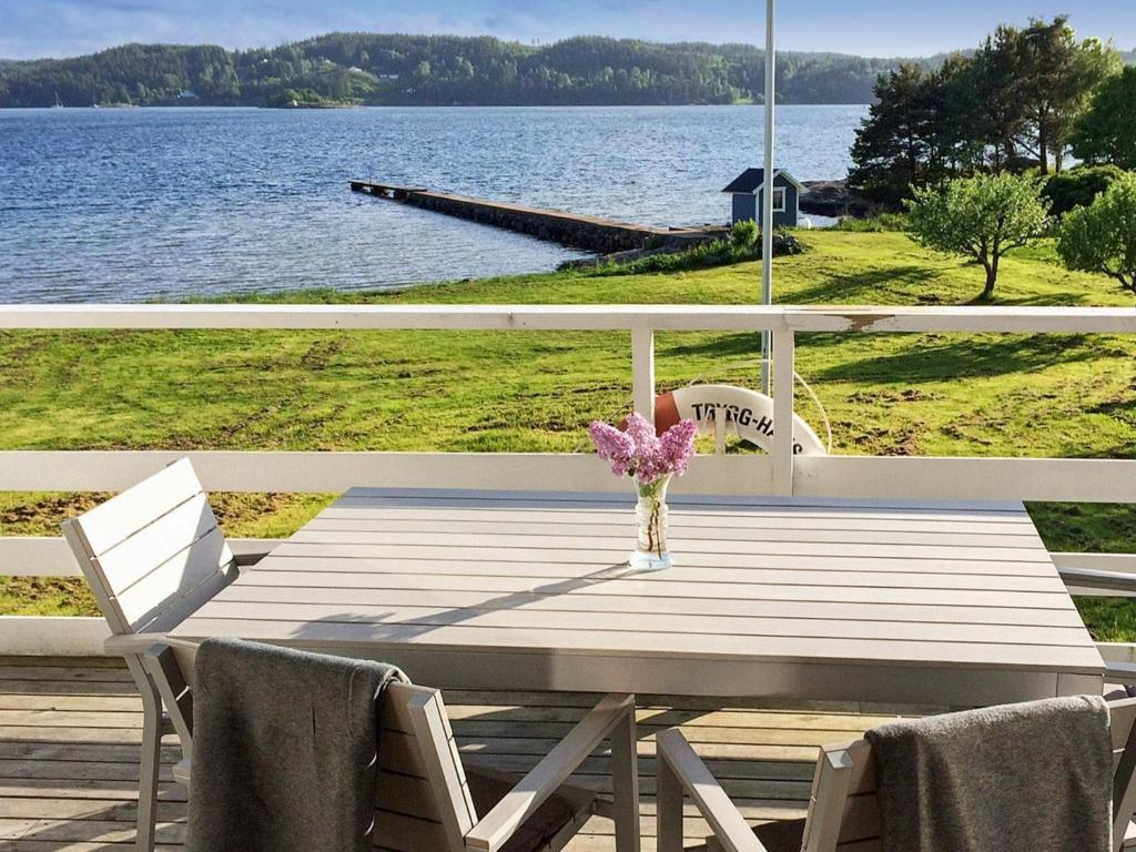 a wooden table with two chairs and a vase of flowers at 8 person holiday home in LJUNGSKILE in Ljungskile