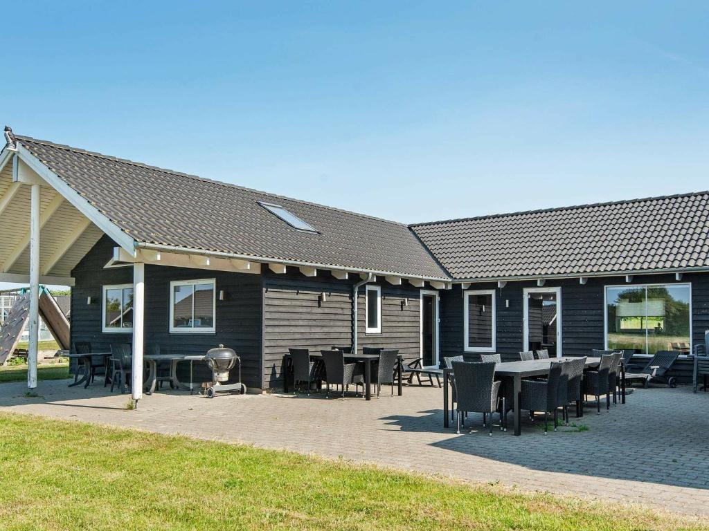 uma casa com mesas e cadeiras em frente em 20 person holiday home in Sydals em Høruphav