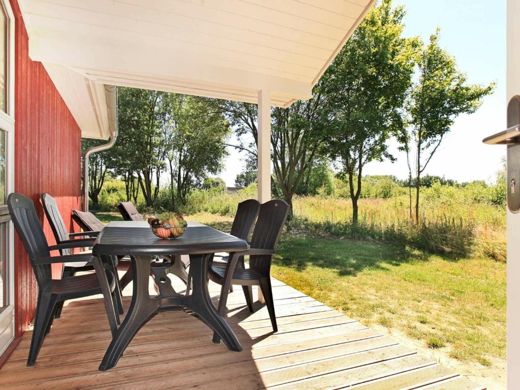 einen schwarzen Tisch und Stühle auf einer Veranda in der Unterkunft 8 person holiday home in Gro enbrode in Großenbrode