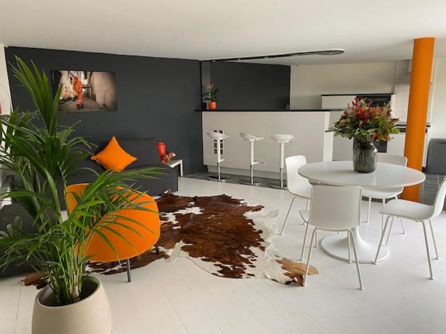 een woonkamer met een tafel en een aantal stoelen en een tafel en een tafel bij Leen & Bruno's NamaStay in Grez-Doiceau