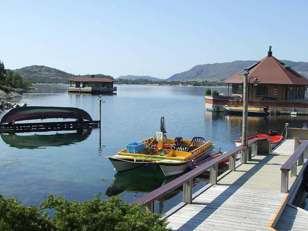 a boat is docked at a dock on a lake at Three-Bedroom Holiday home in Kalvåg in Kalvåg