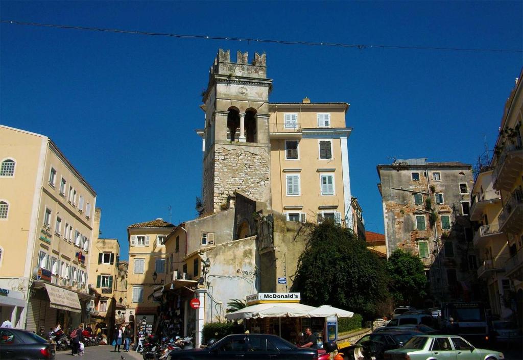 um edifício antigo com uma torre de relógio numa cidade em La Casa Con La Vista Delle Fortezze by CorfuEscapes em Corfu Town