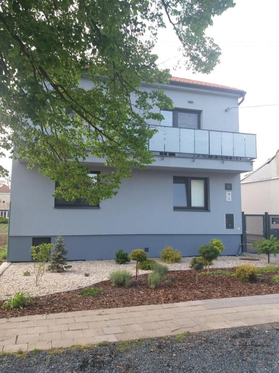 a white building with a balcony on the side of it at Apartmány Relax in Ladná