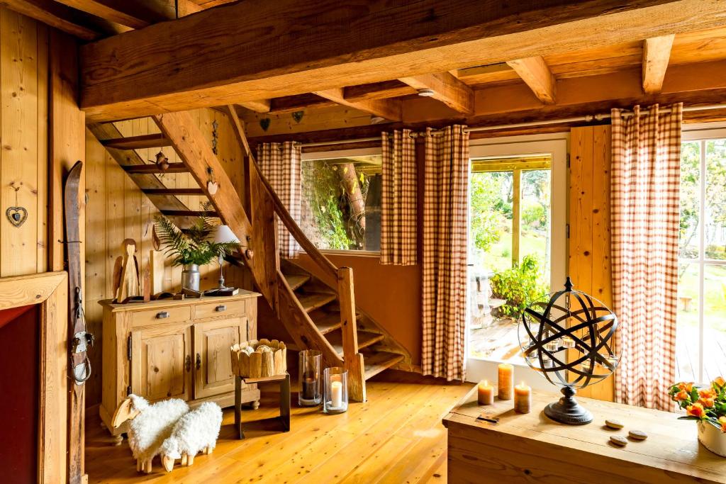 ein Wohnzimmer mit einer Holztreppe in einem Haus in der Unterkunft La Grange du couvent B&B in Ribeauvillé