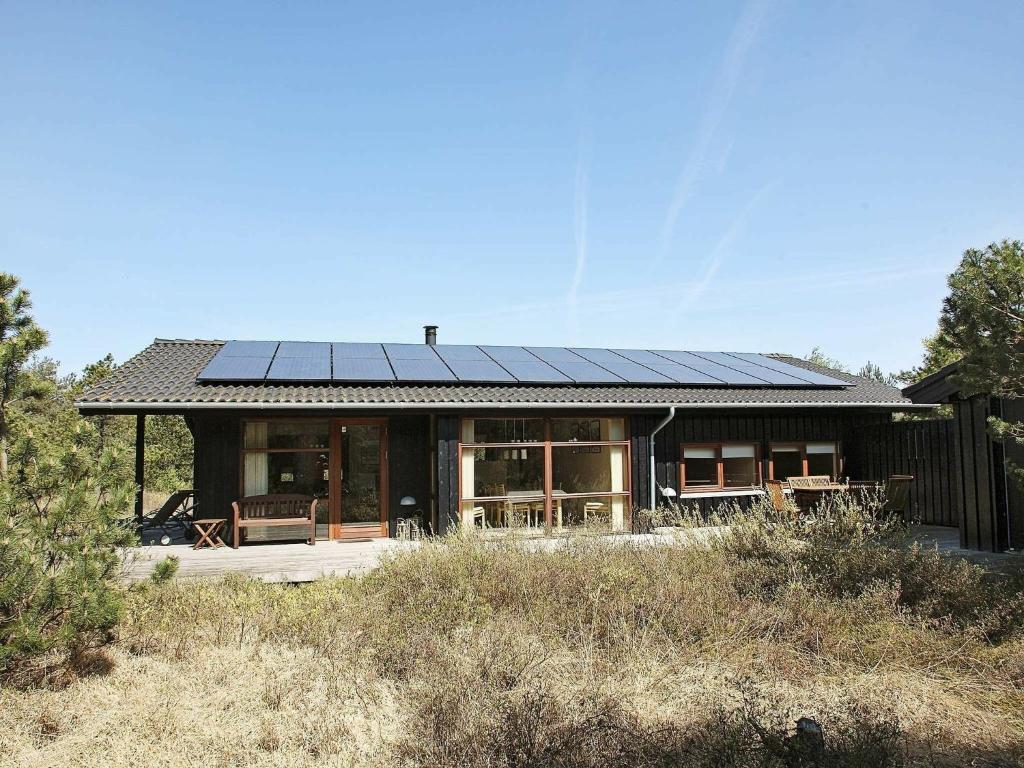 8 person holiday home in Fjerritslev في Torup Strand: منزل عليه لوحات شمسية