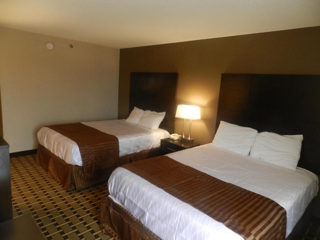 a hotel room with two beds and a lamp at Haven Inn & Suites in Duluth
