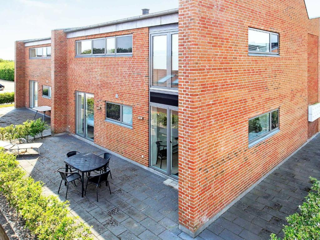 a brick building with a patio with a table and chairs at 8 person holiday home in Hemmet in Hemmet