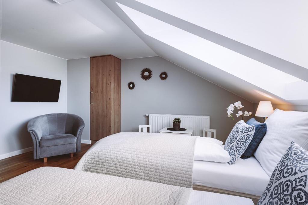 a attic bedroom with a bed and a chair at Górskie Klimaty Myśliwska in Karpacz