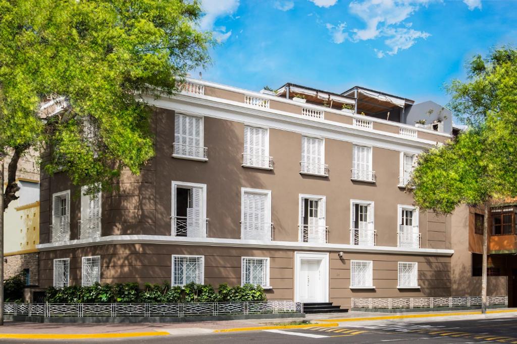 un edificio de apartamentos con ventanas blancas en una calle en Manor House Lima en Lima
