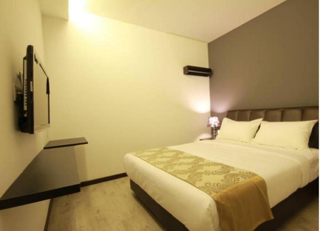 Postel nebo postele na pokoji v ubytování Sandy Hotel Malacca