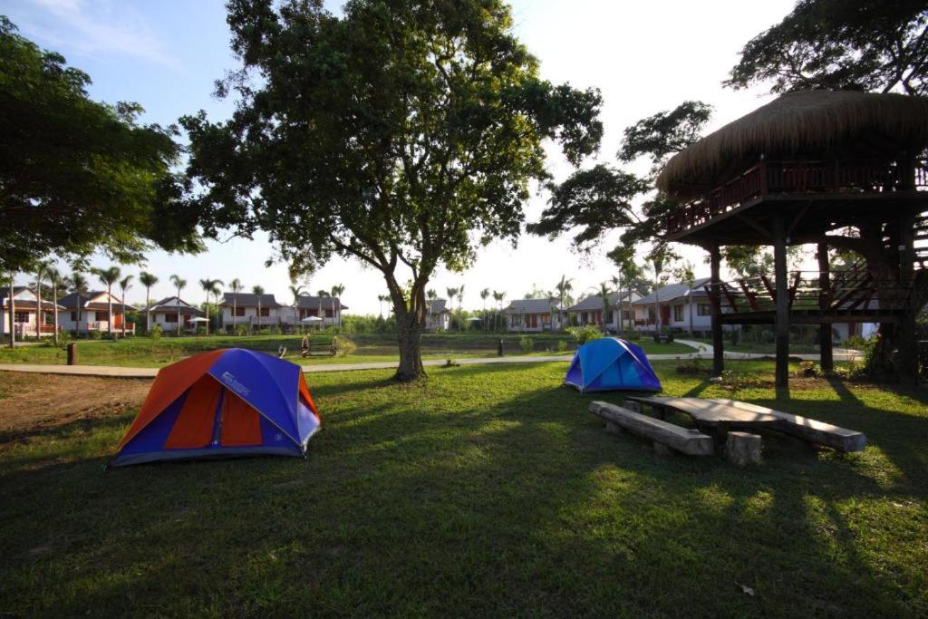 2 tentes assises dans l'herbe dans un parc dans l'établissement Resort Railumpoo (Farm and Camping), à Nakhon Sawan