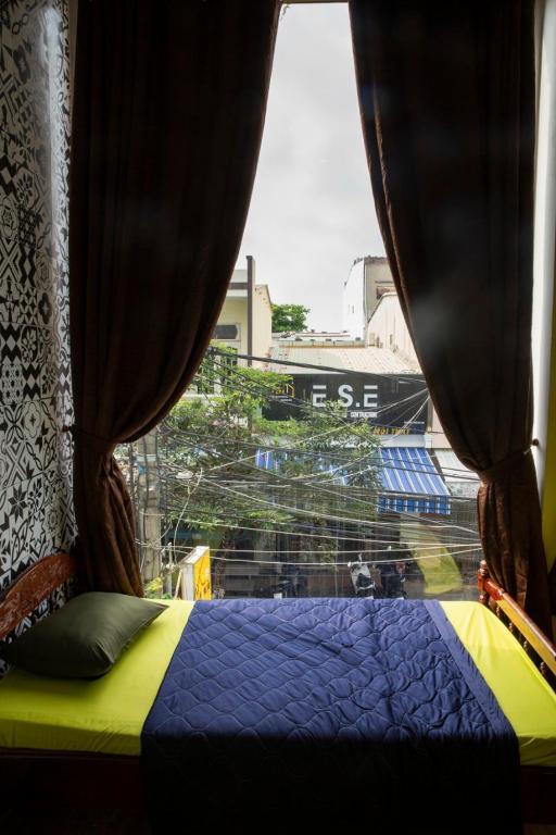 ダナンにあるHomestay Xì Trumのベッドルーム1室(ベッド1台、景色を望む窓付)