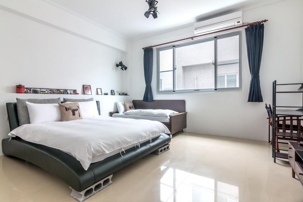 a bedroom with a bed and a window at Ciao Life B&amp;B in Taitung City