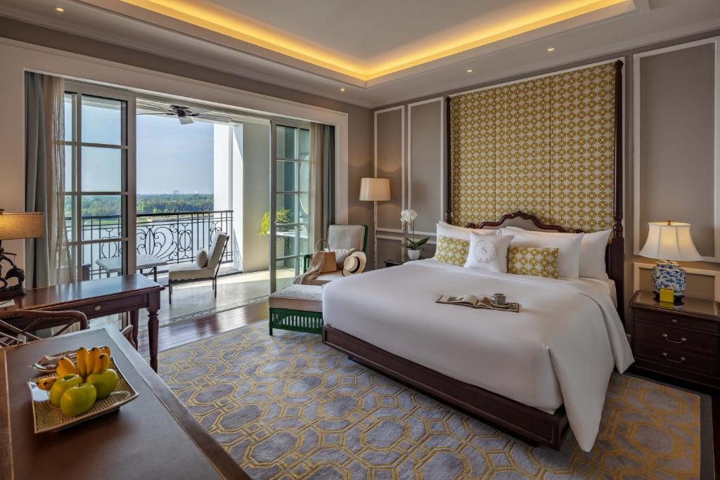 Mia Saigon – Luxury Boutique Hotel في مدينة هوشي منه: غرفة نوم بسرير كبير وبلكونة