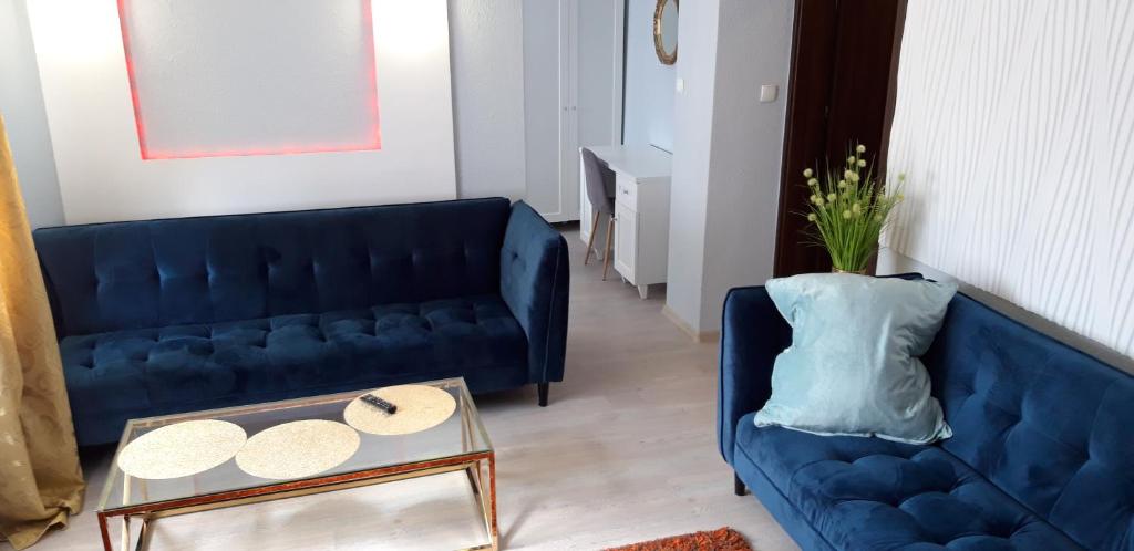 sala de estar con sofá azul y mesa en Noclegi Gwardia, en Koszalin
