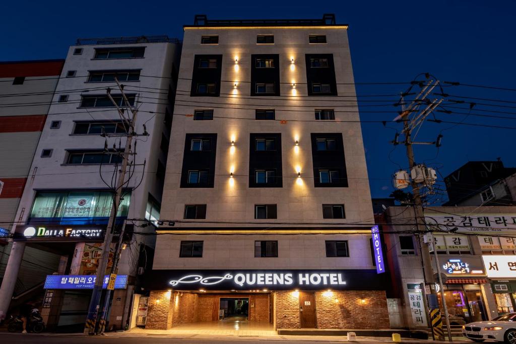 釜山にあるQueens Hotel Seomyeon Busanのクイーンズホテルの看板のある建物