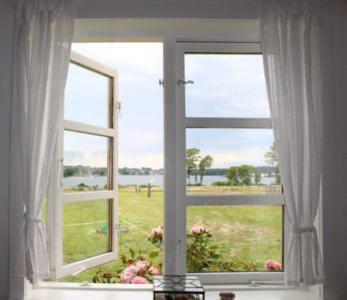 a window with a view of a field of flowers at Grastenhus Guesthouse in Thurø By