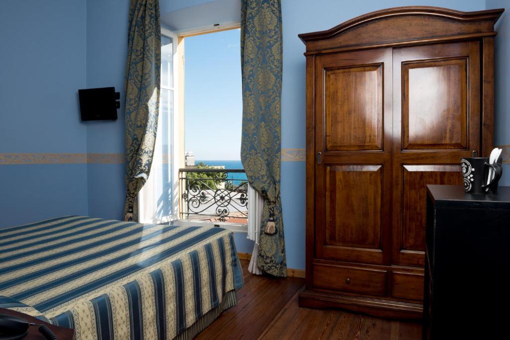 a bedroom with a bed and a large window at Hotel Belle Epoque in Sanremo