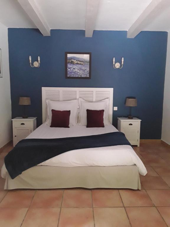 een slaapkamer met een groot bed met blauwe muren bij Mas de l'ile in Avignon