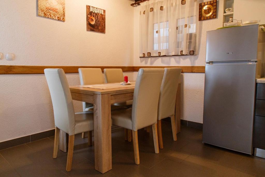 a kitchen with a wooden table and a refrigerator at Holiday Home Vanda in Bakar