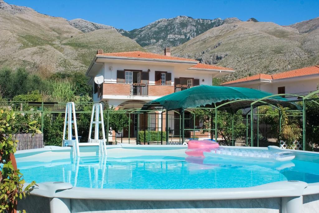 a swimming pool in front of a house with mountains at La Villa dei Limoni - Villa Panoramic with Pool in Formia